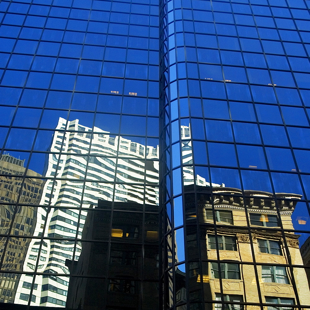 Low angle view of the reflection of buildings on a glass front, Boston, Massachusetts, USA