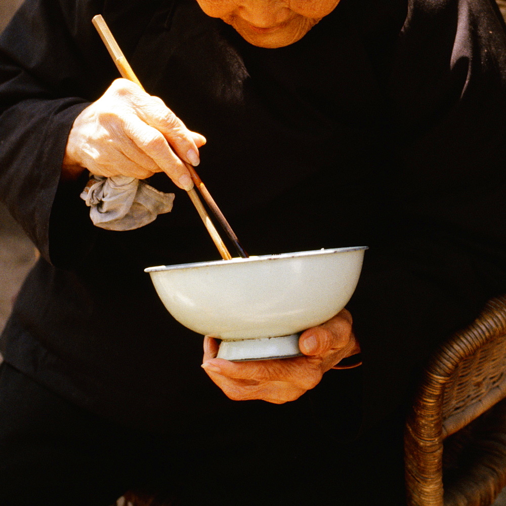 Close-up of a senior man eating with chopsticks, Xian, China