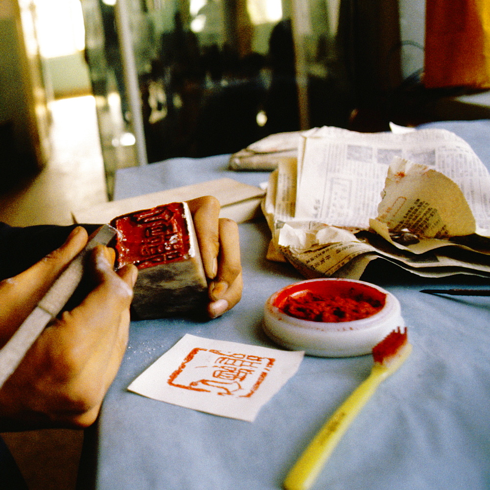 Close-up of a person's hand carving stamp, Xian, China