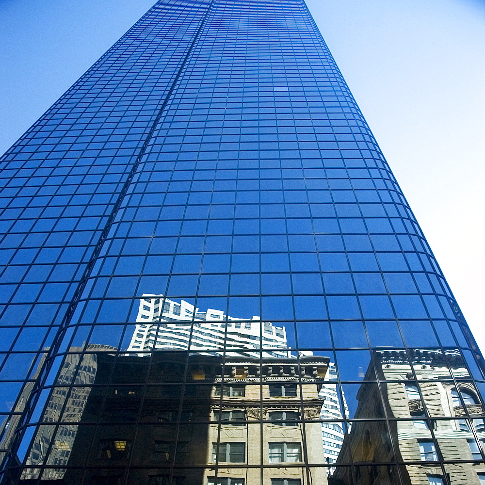 Low angle view of the reflection of buildings on a glass front, John Hancock tower, Boston, Massachusetts, USA