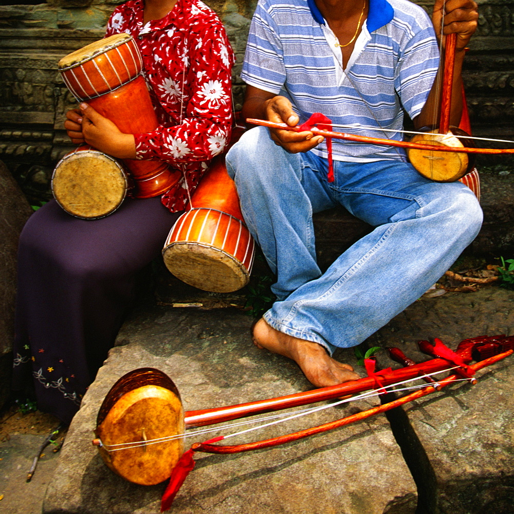 Close-up of two musicians at a temple, Ta Prohm Temple, Angkor, Siem Reap, Cambodia