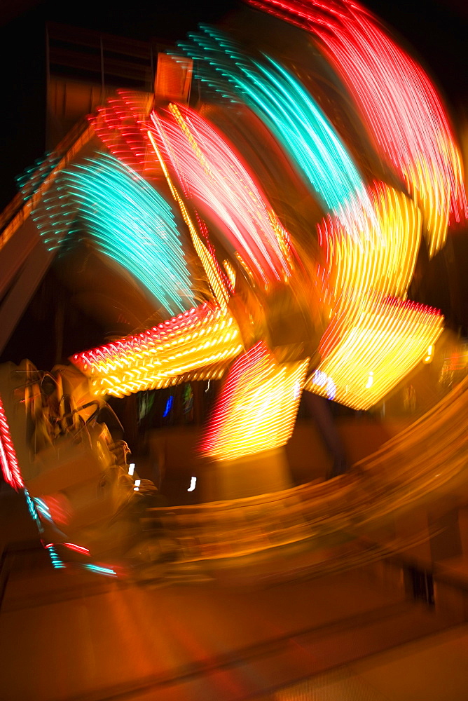 Lights glowing on a carnival ride at night, California, USA