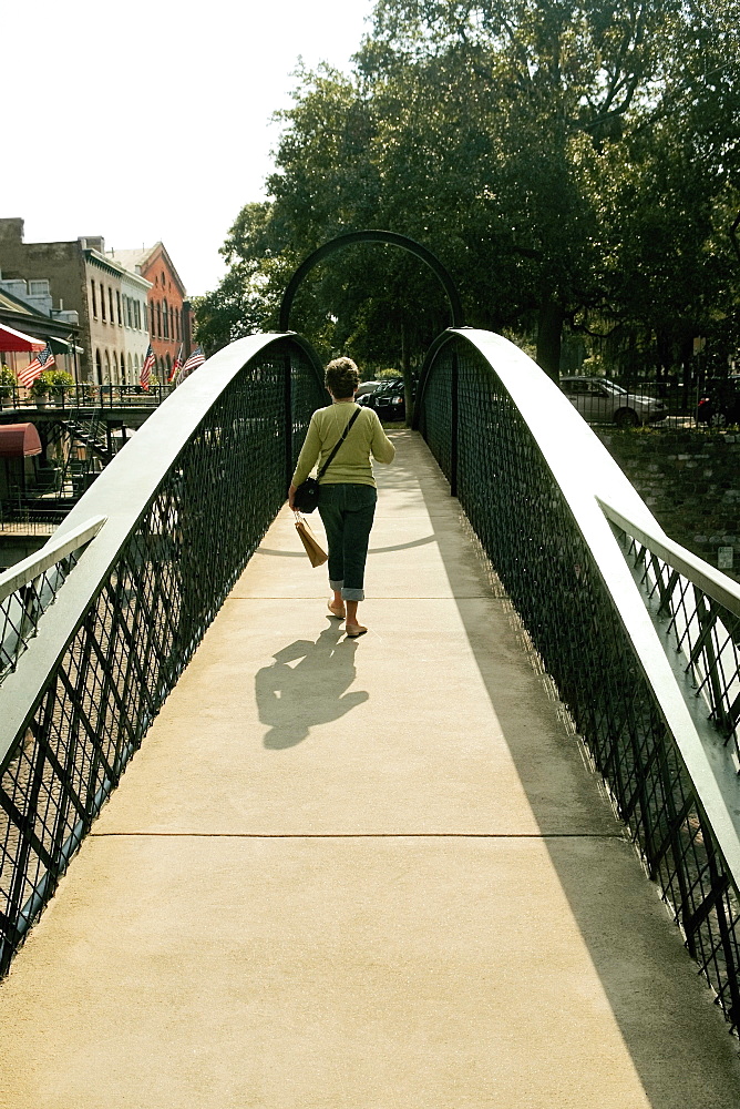 Rear view of a woman walking on a footbridge, Savannah, Georgia, USA