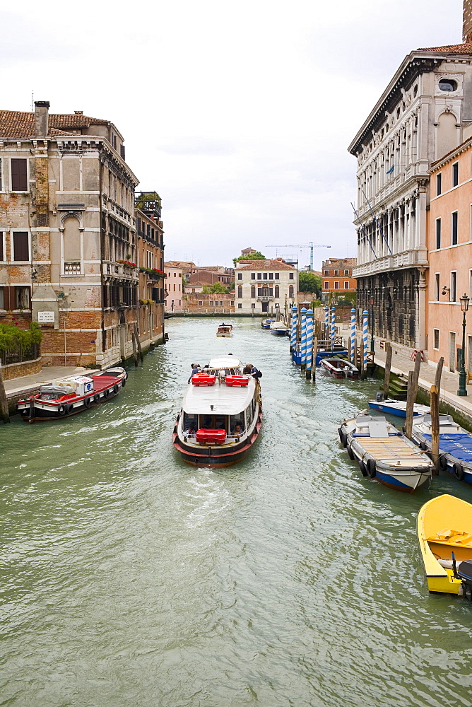 Boats and a water taxi in a canal, Venice, Italy