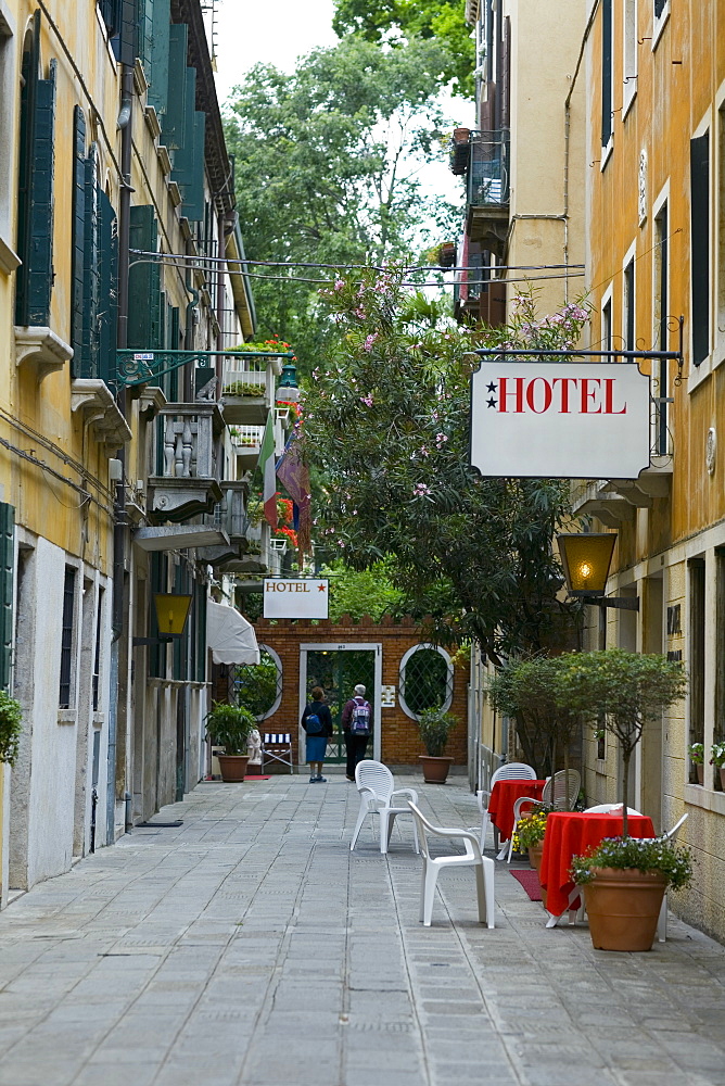 Rear view of two people in front of a hotel on the street, Venice, Italy