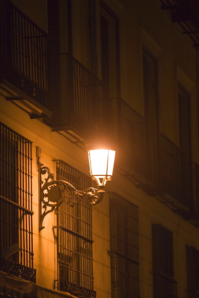 Lantern on a building lit up at night, Madrid, Spain