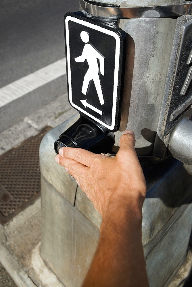 Close-up of a man's hand adjusting a pedestrian crossing signboard, Honolulu, Oahu, Hawaii Islands, USA