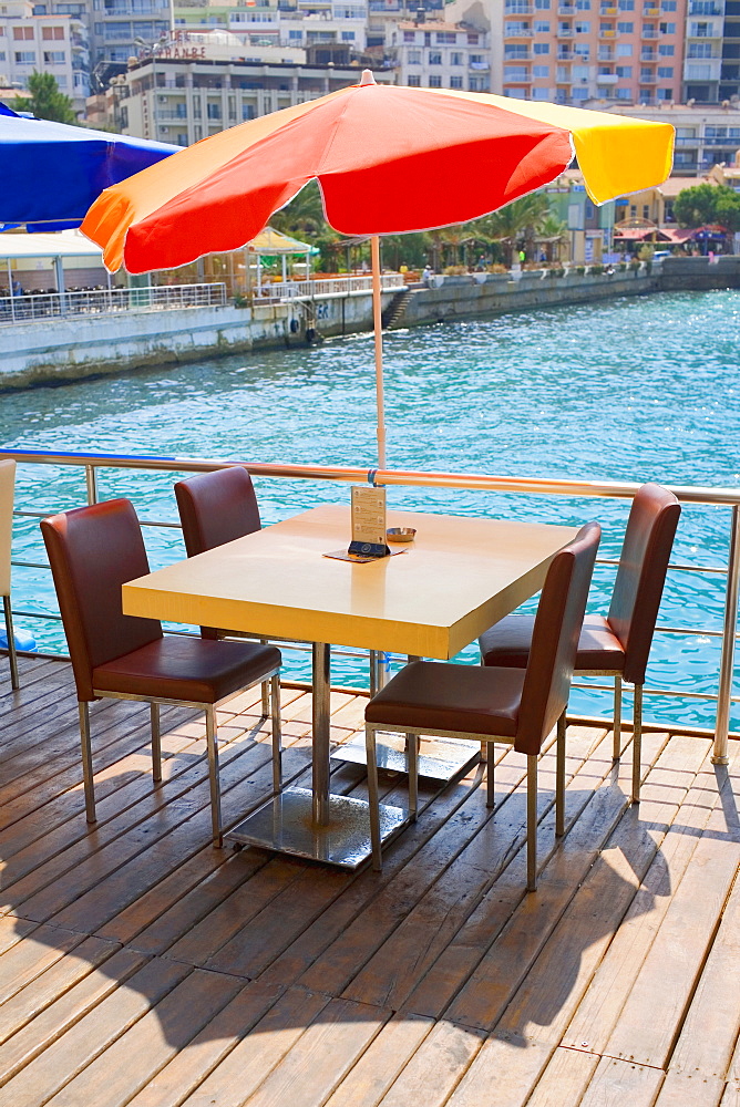 Table with four chairs under a patio umbrella in a restaurant, Ephesus, Turkey