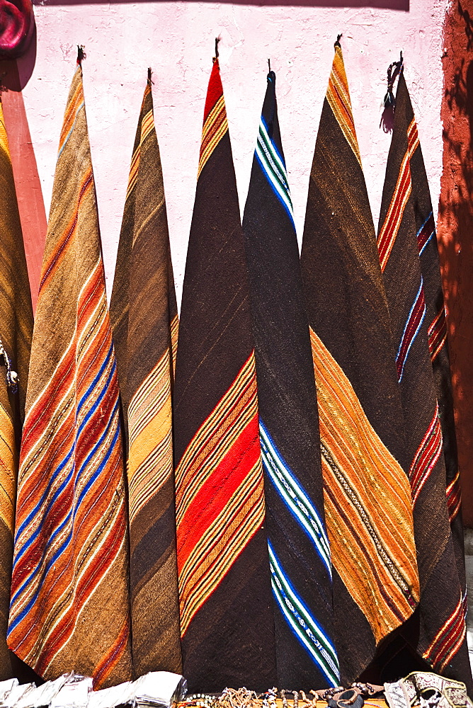 Multi-colored carpets hanging in a market stall, Pisaq, Cuzco, Peru