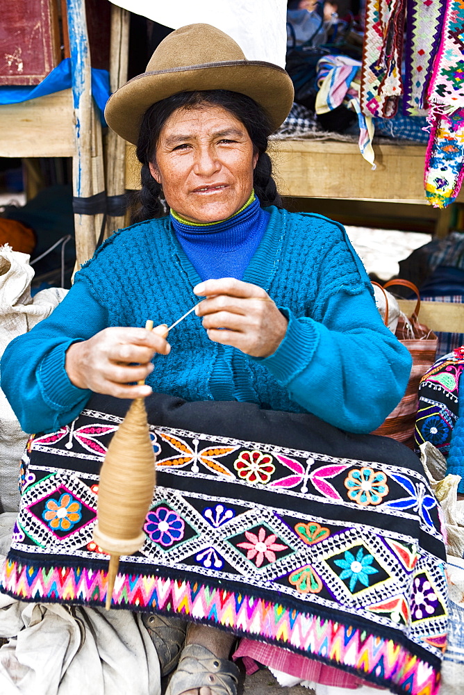 Portrait of a mature woman spinning a spool, Peru