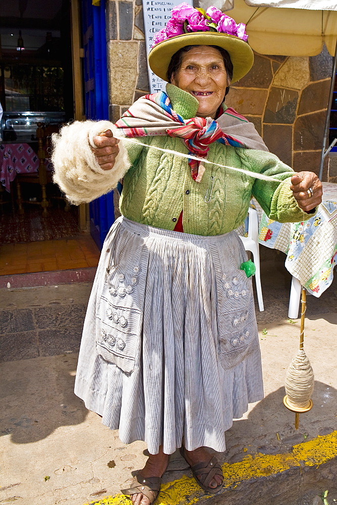 Portrait of a senior woman standing and holding a spool of thread, Peru