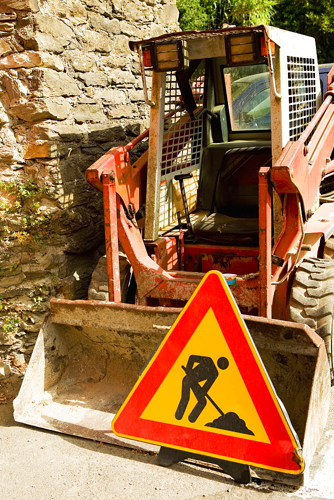 Road construction sign near an earth mover, Vernazza, La Spezia, Liguria, Italy