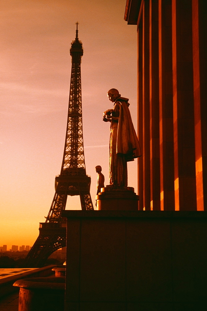 Eiffel Tower seen at the back of a palace statue at sunset, Paris, France