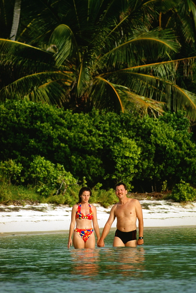 Couple in bathing suit stand knee-deep immersed in water, Abaco, Bermuda