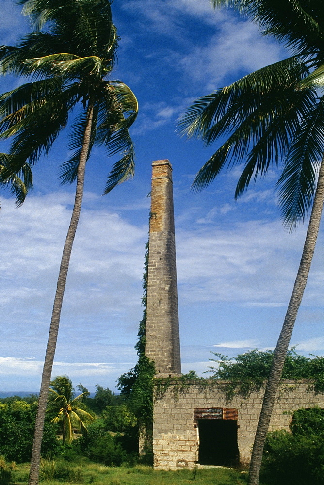 Low angle view of a tall smoke stack and a satellite dish, Barbados, Caribbean