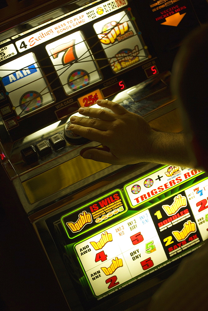 Person's hand in front of a slot machine, Las Vegas, Nevada, USA