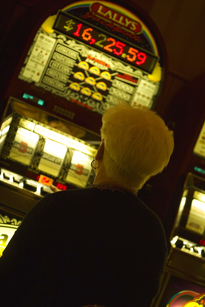 Rear view of a woman standing in front of slot machine, Las Vegas, Nevada, USA