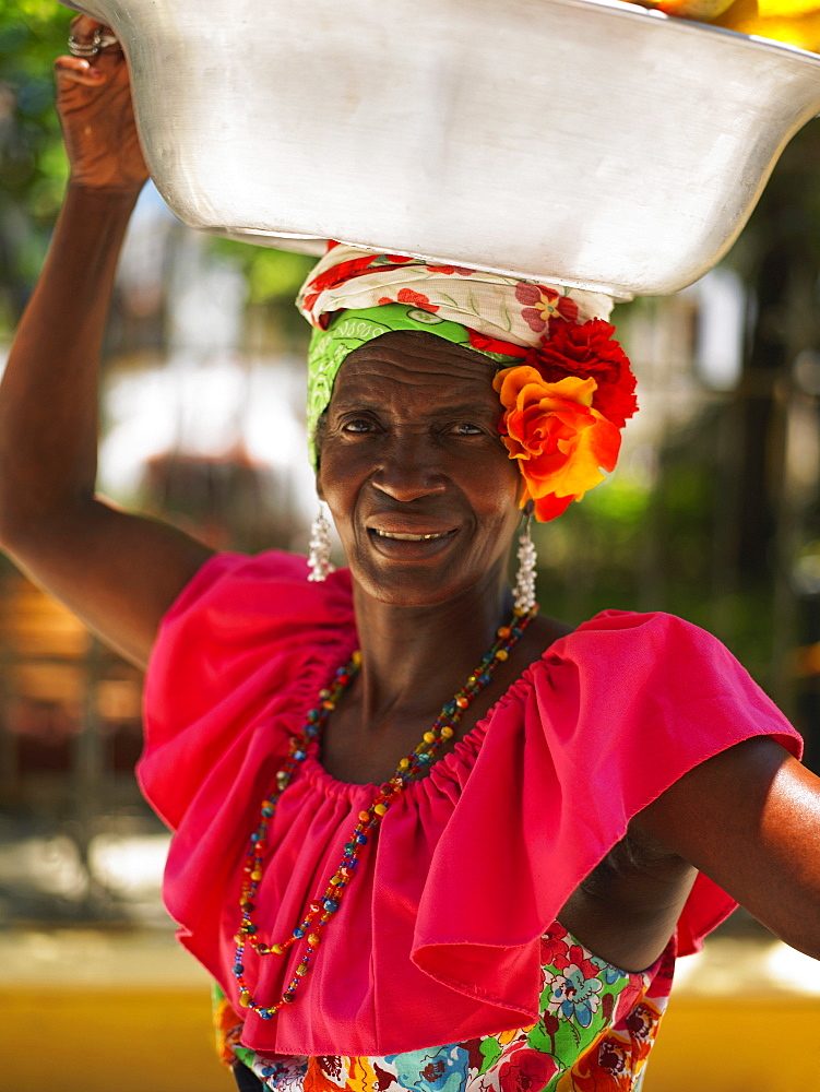 Portrait of a market vendor carrying a basket on her head, Cartagena, Colombia