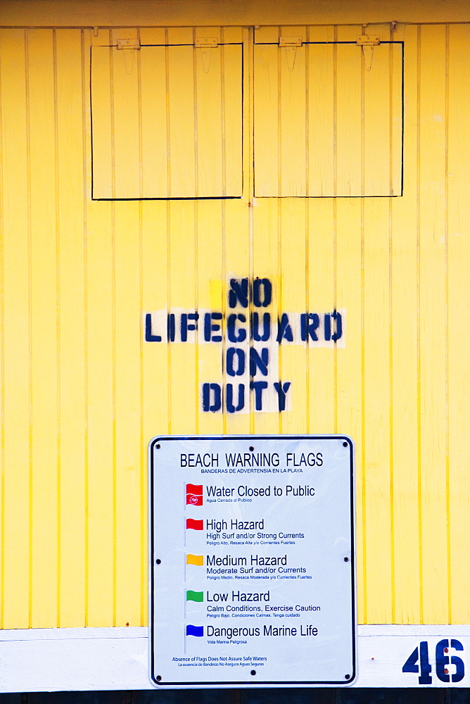 Close-up of a warning sign on a lifeguard hut