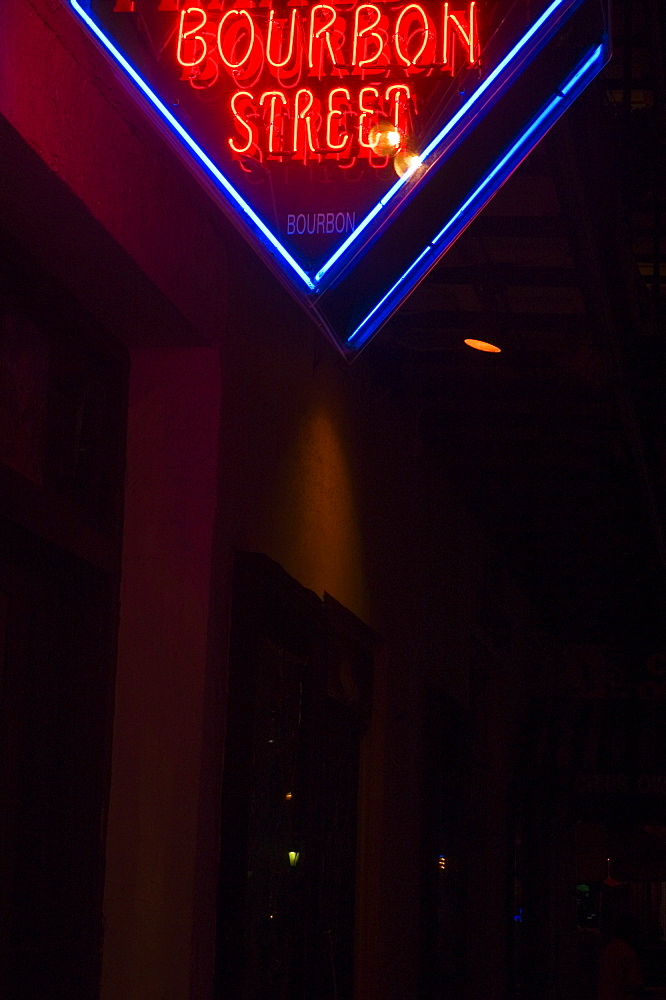 Low angle view of a street name sign lit up at night, New Orleans, Louisiana, USA