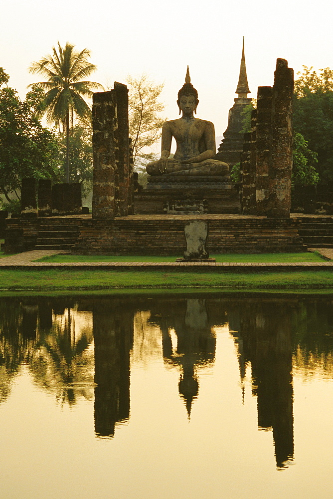 Reflection of a statue of Buddha in water, Wat mahathat, Sukhothai Historical Park, Sukhothai, Thailand