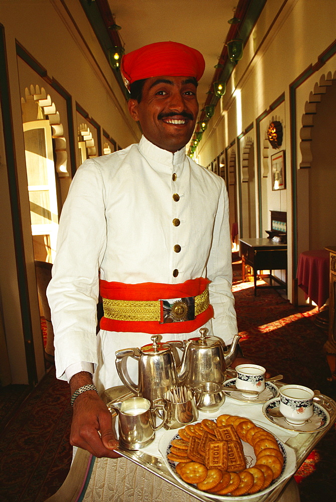 Portrait of a waiter holding a tray and smiling, Fateh Prakash Palace, Udaipur, Rajasthan, India