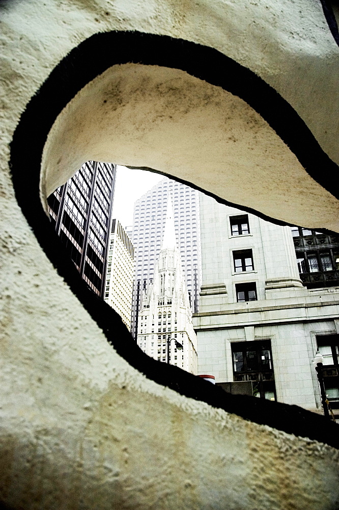 Building viewed through a hole in a modern sculpture, Chicago, Illinois, USA