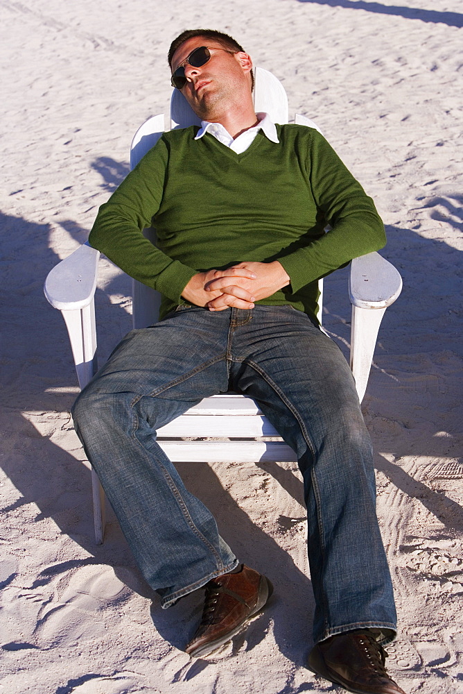 High angle view of a mid adult man reclining on a lounge chair