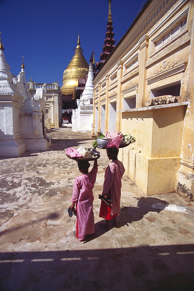 Rear view of two nuns carrying baskets on their head, Bagan, Myanmar