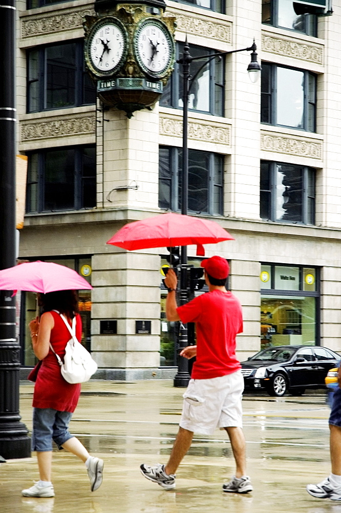 Side profile of pedestrians walking with umbrellas on a sidewalk, Chicago, Illinois, USA