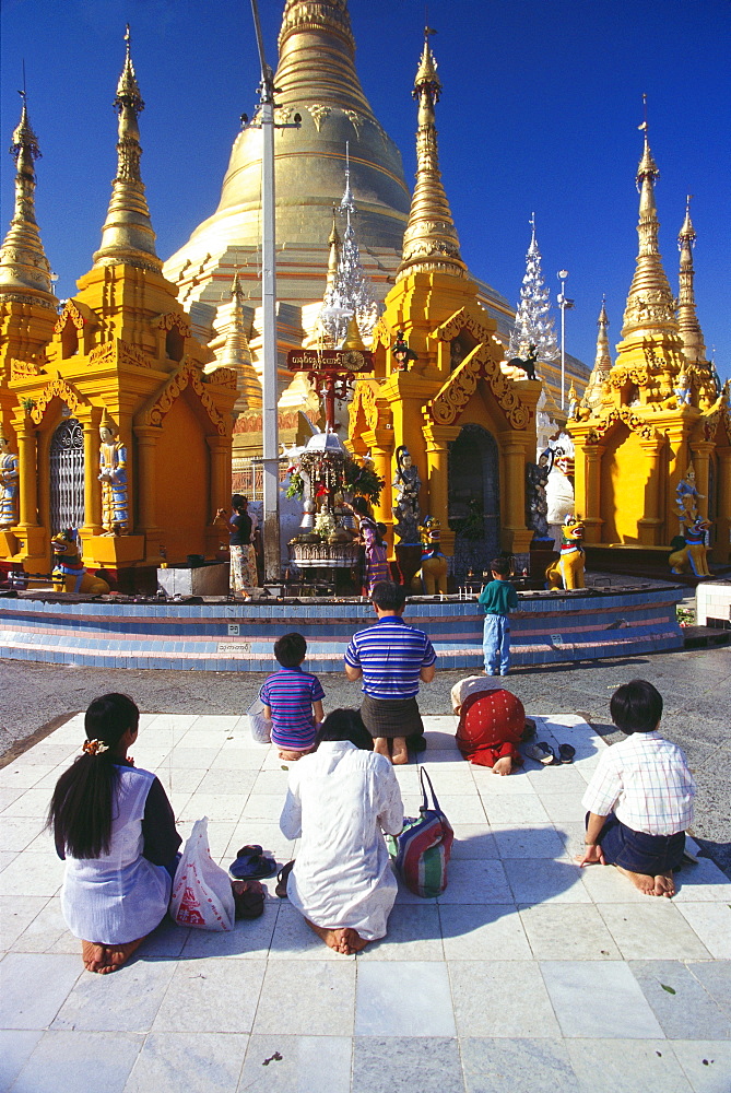 Rear view of pilgrims praying in front of a pagoda, Shwedagon Pagoda, Yangon, Myanmar