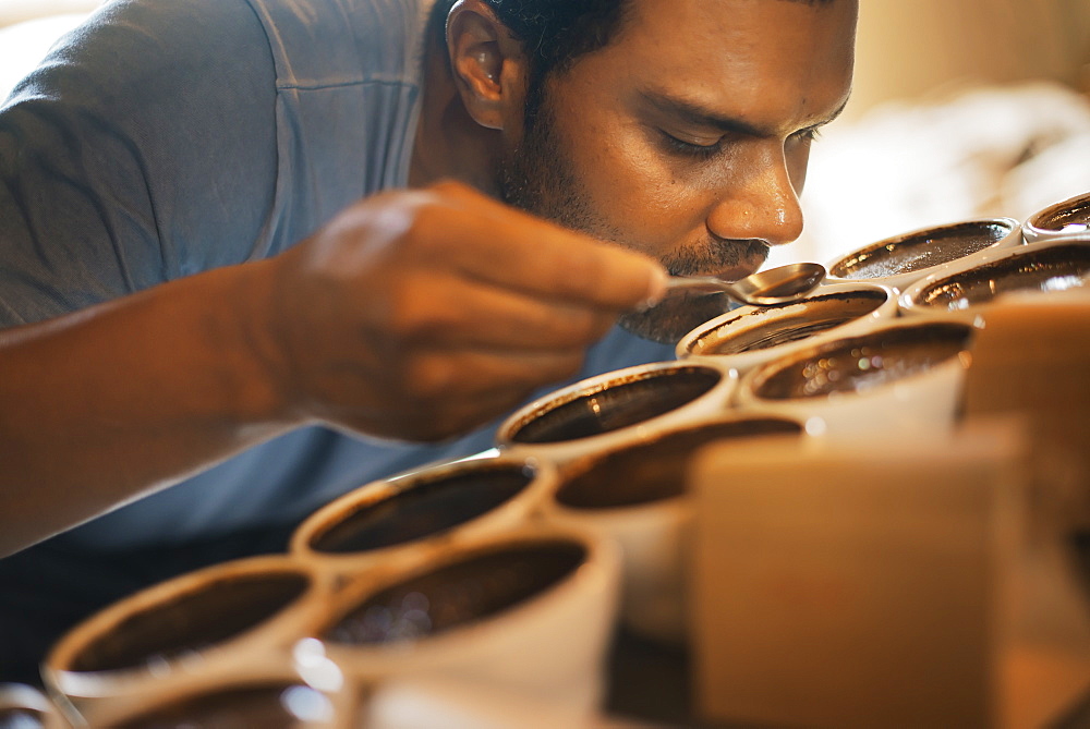 The sampling procedure in a coffee processing shed, where staff make coffee in small pots and sample the taste to test the blend, New York state, USA