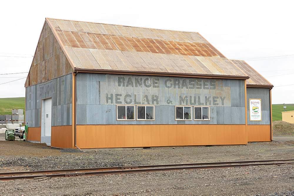 Farm equipment building in a rural setting, deserted.