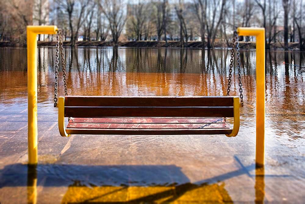 Swing seat in winter, a layer of ice covering the ground