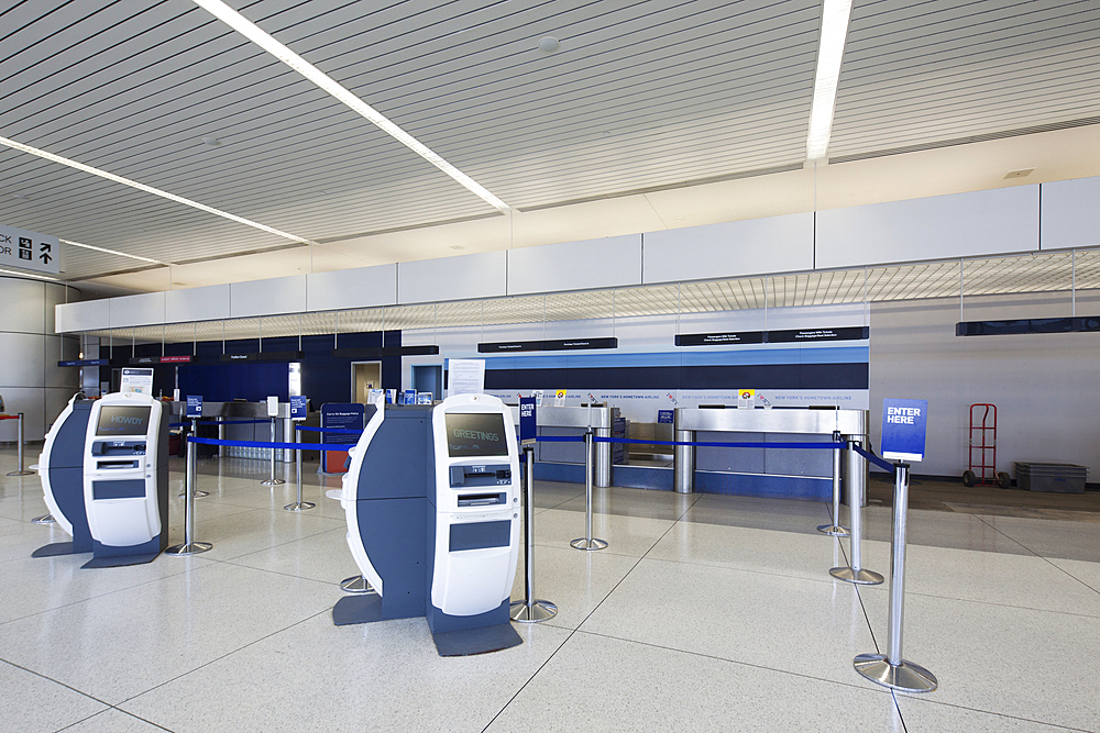 Self check-in desks and traditional baggage check in desks in an empty airport.