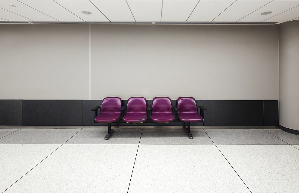 A row of four fixed seats in an empty airport