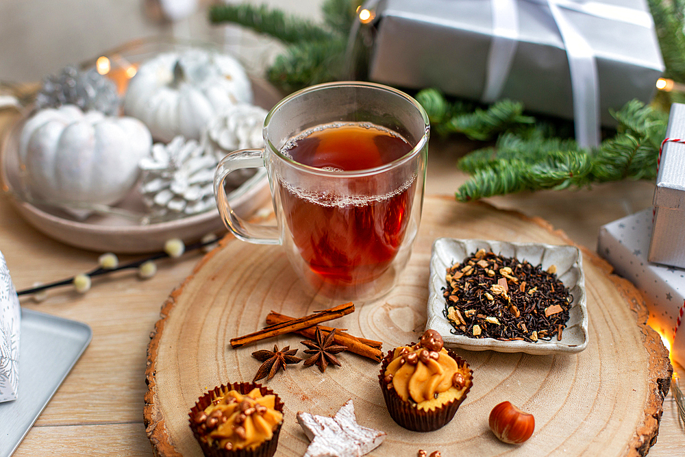 Christmas decorations, a snow globe and presents and star shaped biscuits.