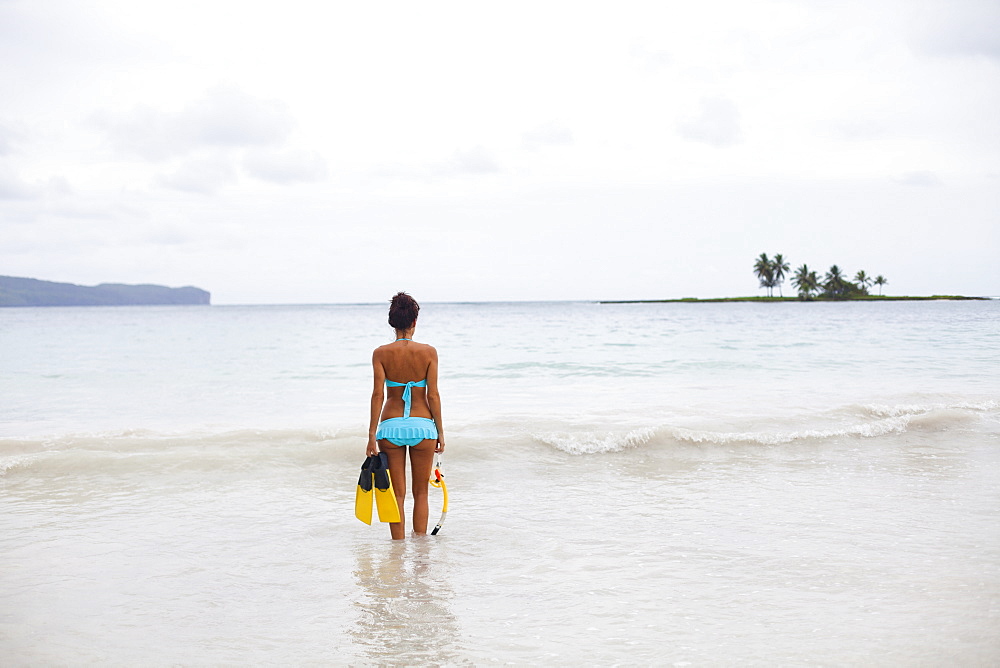 A young woman in shallow water with snorkelling gear on Samana Peninsula in the Dominican Republic, Samana Peninsula, Dominican Republic.