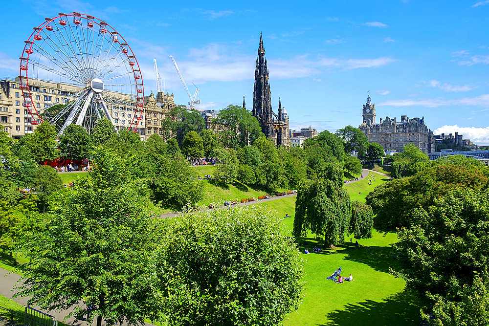 Ferris wheel and Scott monument in park in Edinburgh.