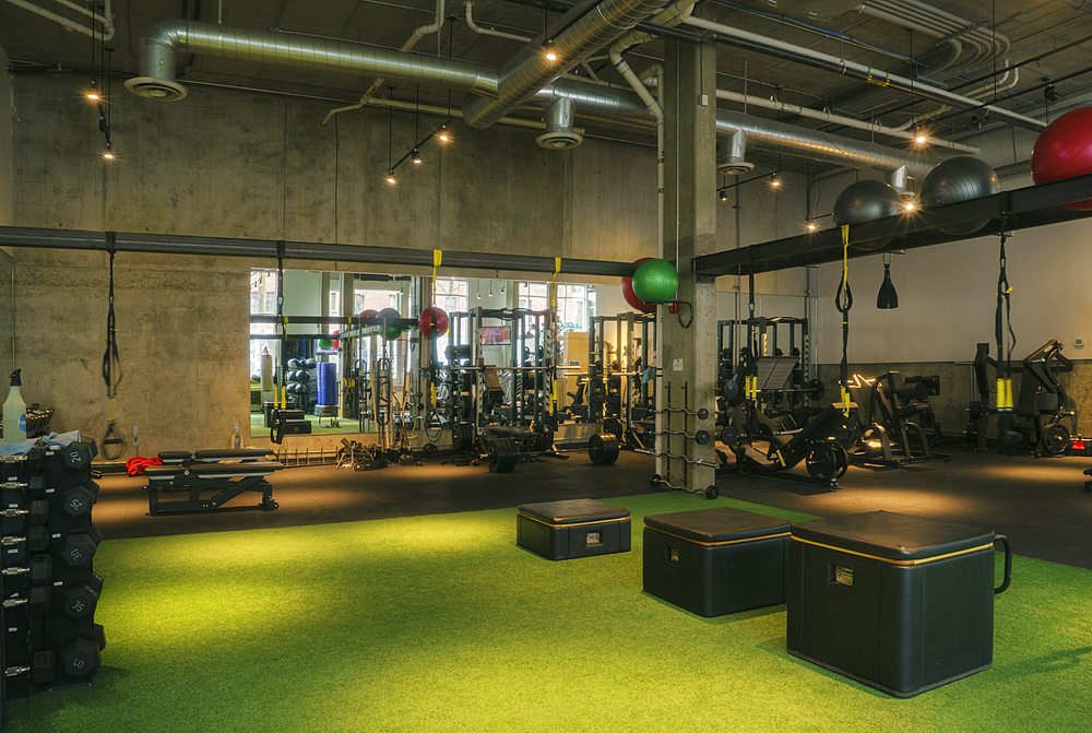 Weights room and exercise equipment in an empty gym.