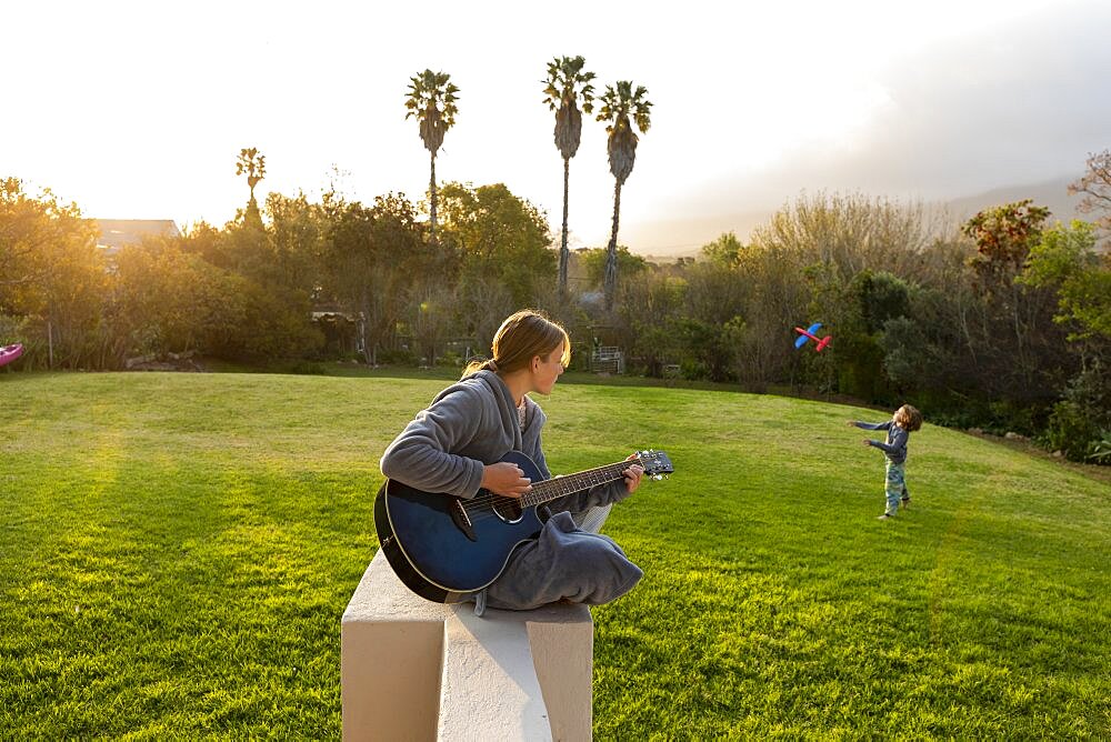 Teenage girl playing guitar and singing outdoors, Stanford, Western Cape, South Africa