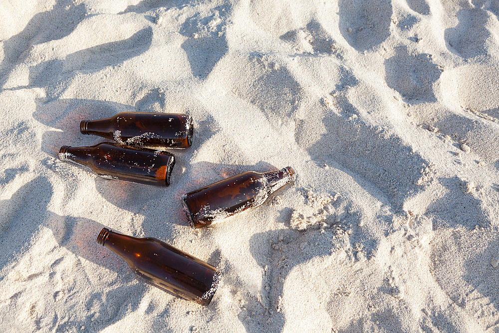 Empty abandoned beer bottles on beach