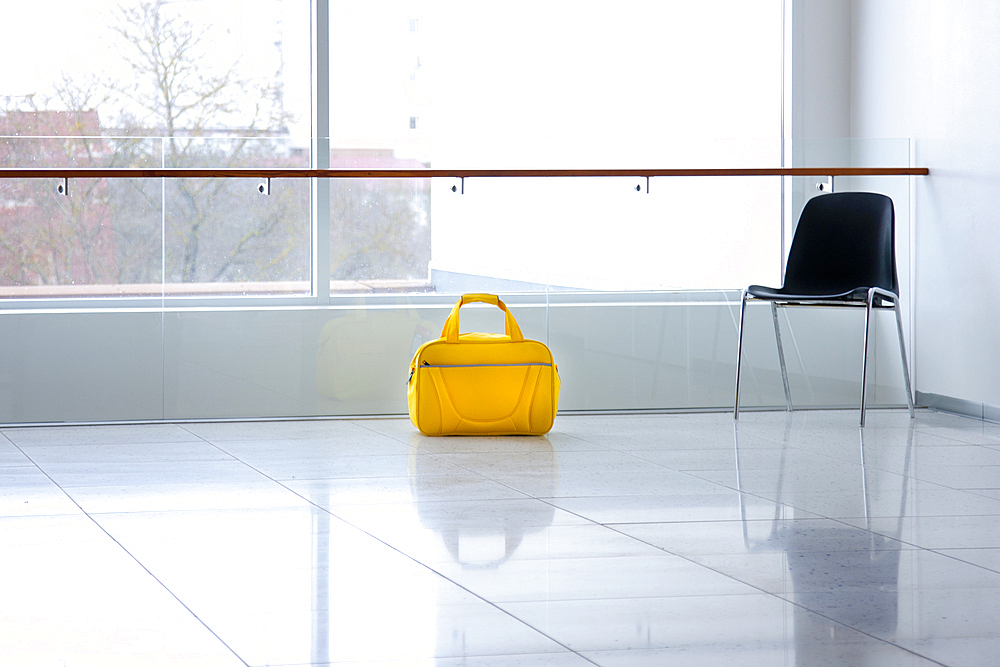 A yellow bag in a light and airy empty corridor  Yellow bag.