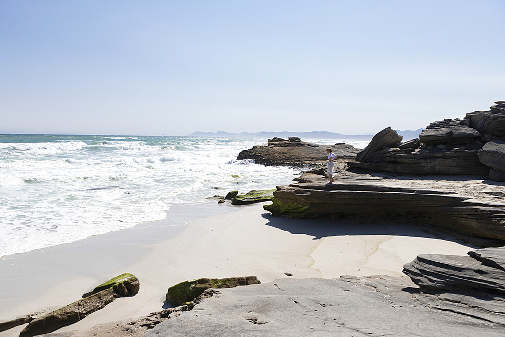 Teenage girl exploring a rocky shore on the Atlantic ocean coastline
