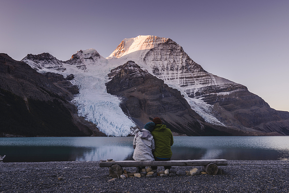 Couple in front of Mount Robson above Berg lake at dawn.