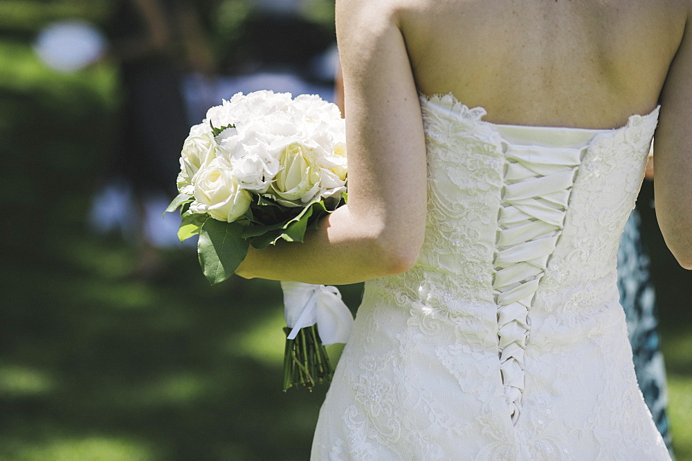 A bride in a fitted bodice, white dress with lacings across the fitted back panels, Bridal gown, Varese, Italy