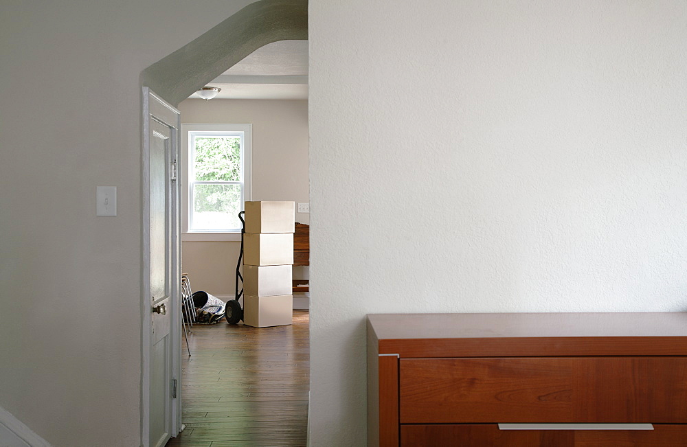 Moving house, relocation, cardboard boxes piled up in a house