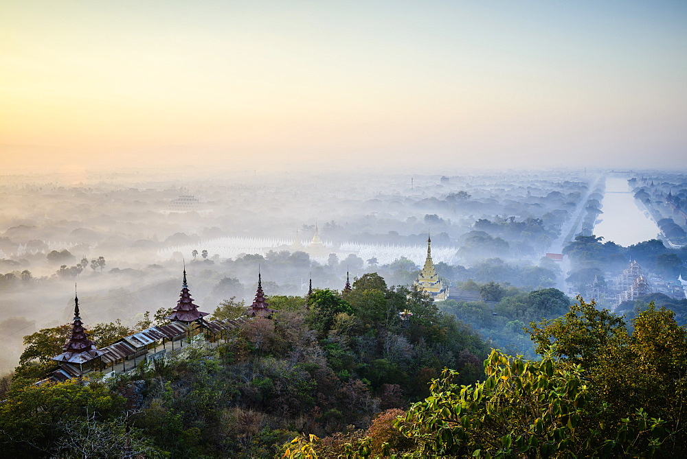Elevated view of the plain of temples in Mandalay, stupas and spires emerging from the mist, historic Buddhist sites, Myanmar