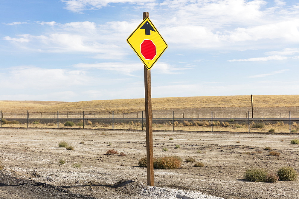 Stop Sign ahead, a yellow sign and red circle with arrow, roadside safety sign.