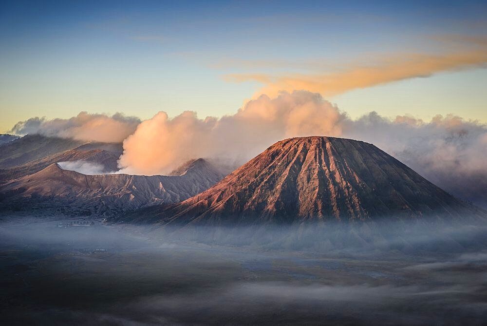 Mount Bromo volcano, a somma volcano and part of the Tengger mountains range, the cone rising above mist in the landscape.